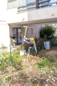 Jardinier près de la terrasse dans un jardin en cours de dégagement à Buc