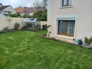 Pelouse et massifs devant la façade de la maison