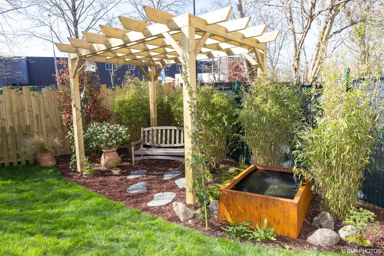 Jardin terminé avec pergola en bois, banc, bassin en acier corten, bambous et gazon à Buc