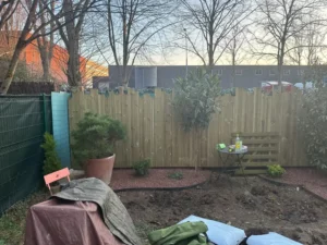 Panneaux bois installés au fond du jardin, massif en cours, à Buc