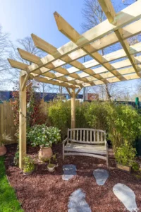 Pergola en bois, banc et pas japonais dans le coin zen à Buc