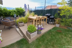 Terrasse en bois avec table, barbecue et jardinière
