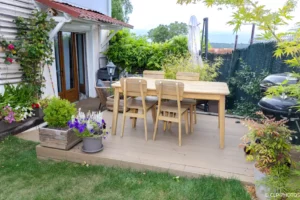 Terrasse en bois avec table à manger devant la façade